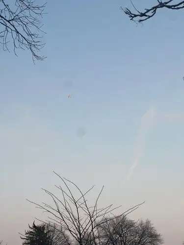 A small orange spark in the cool, wide open sky.